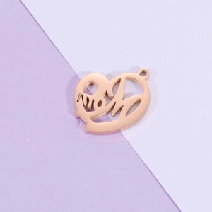 Macro view of rose gold heart pendant with hollow 'mom' lettering design