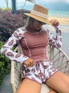 Detail of long-sleeve surfing swimwear with palm leaf print and drawstring shorts