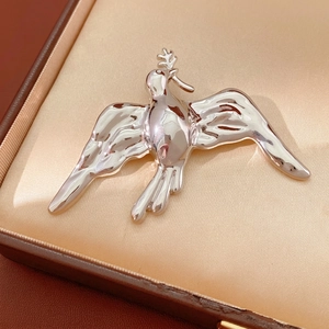 Polished silver bird brooch with olive branch in a luxury jewelry gift box