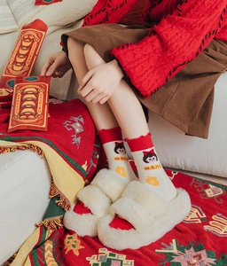 Detail of red-trimmed crew socks with cute girl embroidery and festive patterns