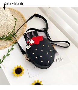 Close-up of black strawberry shaped girls crossbody bag with gold studs and daisy detail