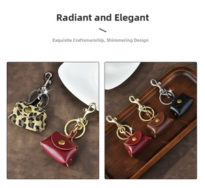 Miniature leather bag keychains in leopard, red, and brown on a wooden tray