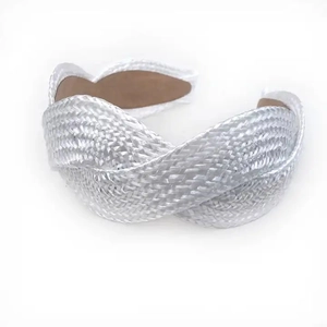 Macro detail of braided texture and shimmering metallic finish on white wide headband