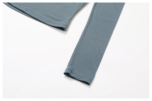 Detailed view of sleeve cuff and hem stitching on blue compression sports yoga top