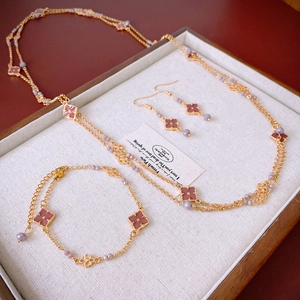 Dettaglio del set gioielli a quadrifoglio con collana e orecchini su espositore vintage