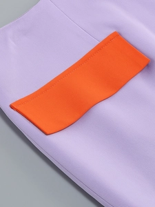 Detail of purple fabric with orange pocket contrast and precise stitching on the dress