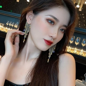 Elegant gold star tassel drop earrings for women featured on a fashion model