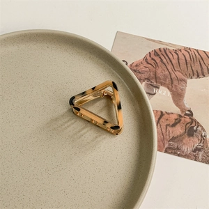 Detail of triangle acetate hair claw with tortoise shell pattern on a golden base