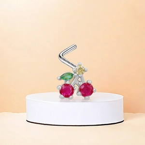 Macro detail of cherry-shaped L-bar nose stud with red zircon and silver metal finish