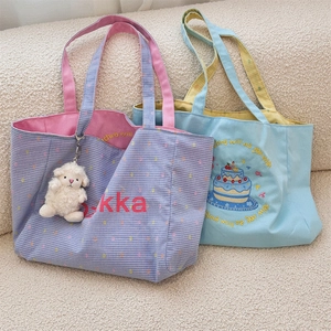 Close-up of contrast color canvas tote bags with embroidery and cute sheep keychain