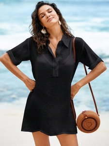 Detail of black short sleeve shirt dress with textured fabric and button placket