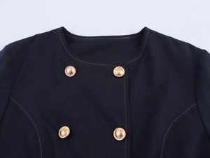 Detail of navy double-breasted top with gold buttons and contrast orange topstitching