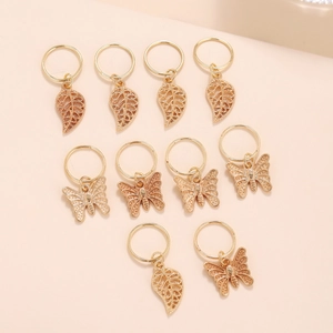Detail of gold metal hair rings with delicate butterfly and leaf pendant charms