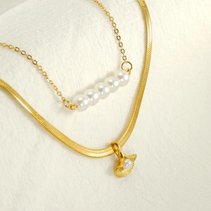 Double-layered gold necklace set with ginkgo leaf pendant and white pearl details