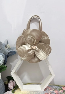 Detailed close-up of a floral golden tote bag with pearl accents and metallic petals