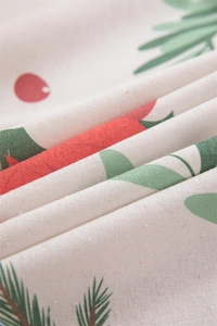 Macro view of Christmas printed fabric featuring festive berries and pine needles