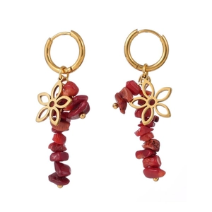 Détail du pendentif fleur dorée et perles en pierre naturelle rouge sur les boucles