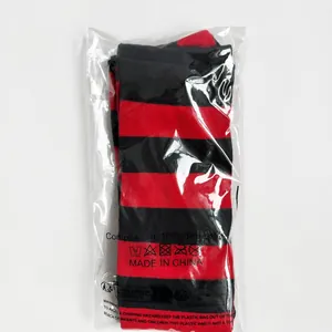 Retail packaging detail of red and black striped thigh high socks made of 100% polyester