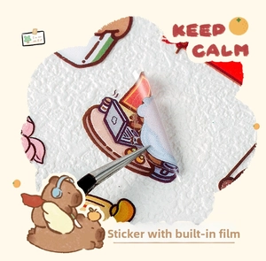 Close-up of die-cut Capybara stickers being peeled with tweezers on textured paper