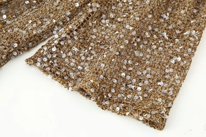 Gros plan sur le tissu crocheté à paillettes dorées avec maille fine pour robe