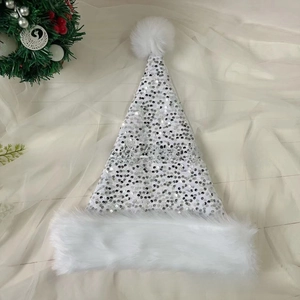 Detailed view of white Christmas hat with shiny silver sequins and soft plush trim texture