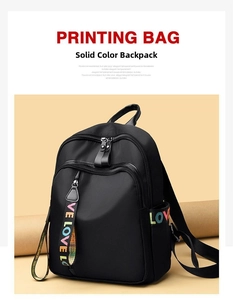 Close-up of black Oxford cloth backpack with LOVE embroidery and decorative ribbon