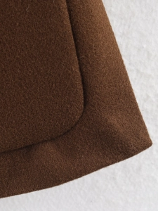 Close-up of brown wool coat fabric texture and high-quality round edge stitching details