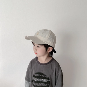 Détail d'un enfant portant une casquette respirante beige et un t-shirt gris anthracite imprimé