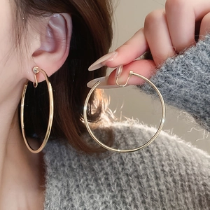 Detail of large gold hoop ear clip with U-shaped structure and transparent protection pad