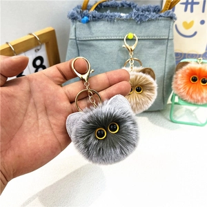 Plush cat ball keychains in grey, brown, and orange with golden metal lobster clasps