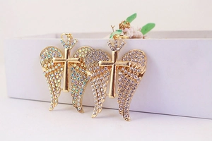 Detailed shot of gold cross and wing keychain pendant with sparkling rhinestones