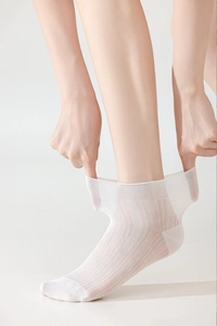 Detail of breathable white thin socks showing high elasticity and ribbed texture