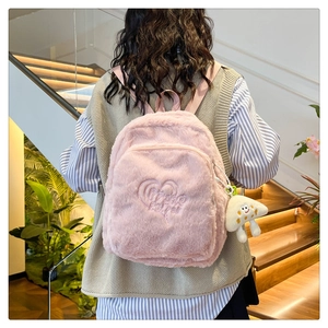 Detail of pink plush backpack with heart embroidery and a white cloud plush charm