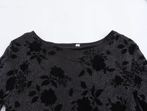 Detail of round neckline on black knit dress with velvet floral texture and metallic shimmer