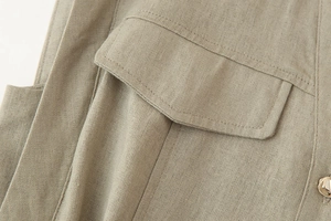 Detailed macro view of a flap pocket on a khaki linen sleeveless V-neck maxi dress