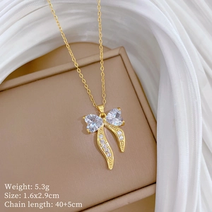 Close-up of golden bow necklace with crystals and specific product dimensions and weight