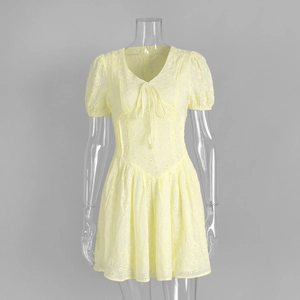 Close-up of yellow cotton dress featuring intricate floral embroidery and cut-out details
