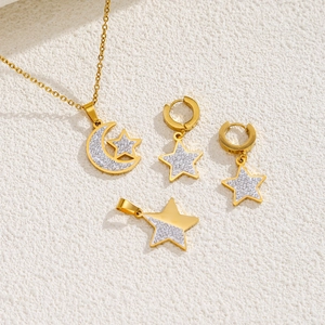Détail d'une parure de bijoux plaquée or 18k avec pendentifs étoile et lune brillants