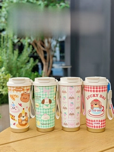 Outdoor shot of portable cartoon coffee mugs with woven handles and ceramic lining