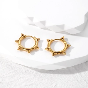 Golden punk spike hoop earrings for men in polished stainless steel on white pedestal