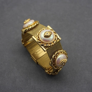 Vintage gold mesh bracelet featuring large pearl inlays and intricate heart accents