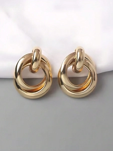 Macro detail of intertwined thick gold rings with polished interlocking metal finish