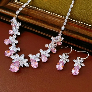 Vue détaillée d'une parure en argent avec fleurs, gouttes d'eau et zircons roses et clairs