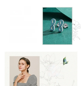 Macro detail of S925 sterling silver infinity earrings with turquoise stone inlays