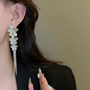 Detail of silver flower tassel earrings with sparkling rhinestones on model