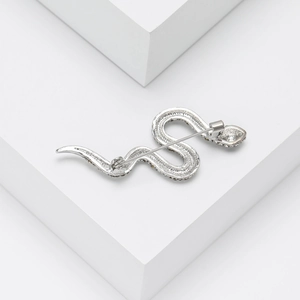 Detailed back view of silver snake brooch with crystal rhinestones on geometric stand