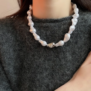 Détail du collier de perles baroques avec perle argentée sur cou de femme élégant
