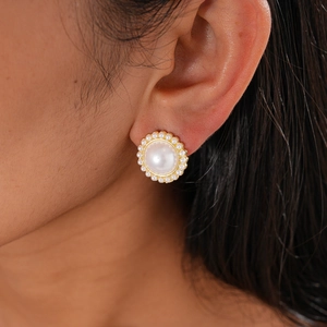 Gros plan sur un élégant clou d'oreille fleur en perle avec détails dorés vintage