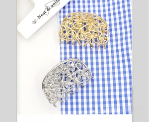 Detail view of the intricate hollowed-out metal butterfly hair claw clip in gold and silver
