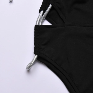 Detail of black swimsuit with silver metallic cords and hollow-out side design texture